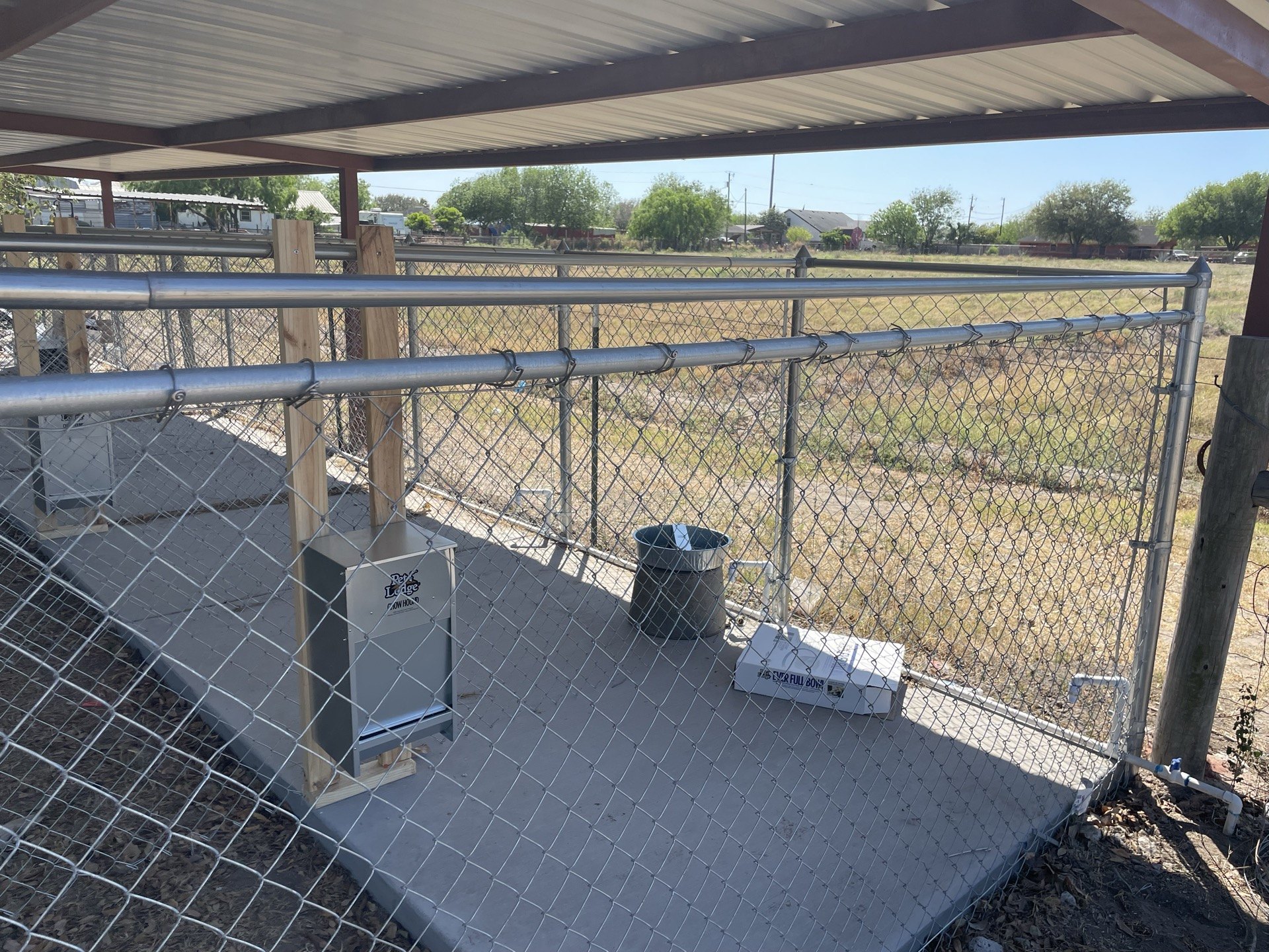 Chain-link panels beneath the covered section of an Edinburg enclosure