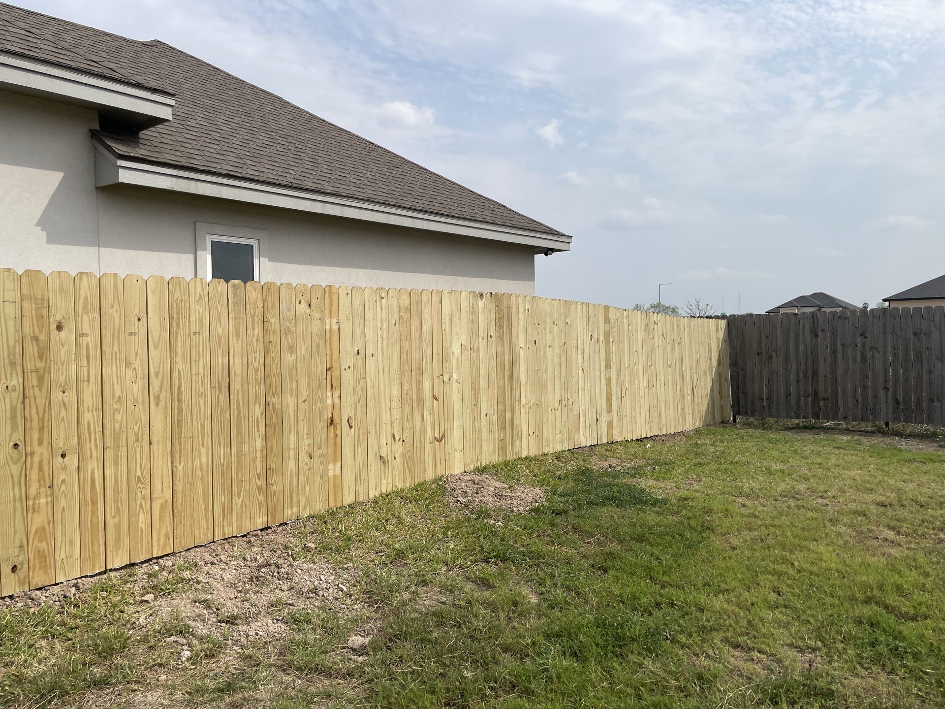 Vertical wood privacy fence along a McAllen backyard