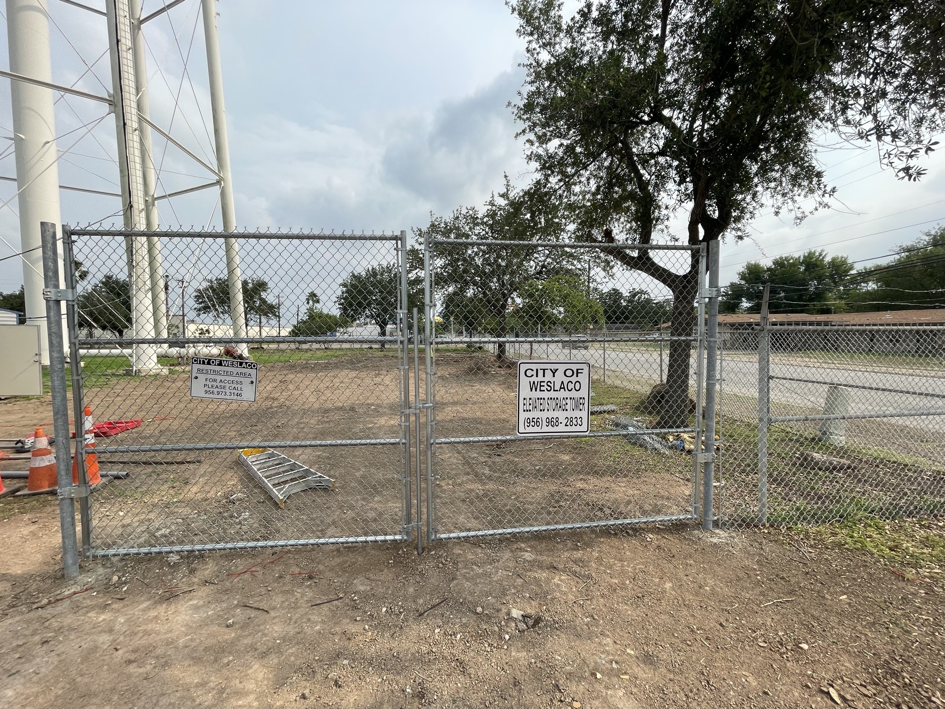 Double chain link access gate beneath the Weslaco water tower.