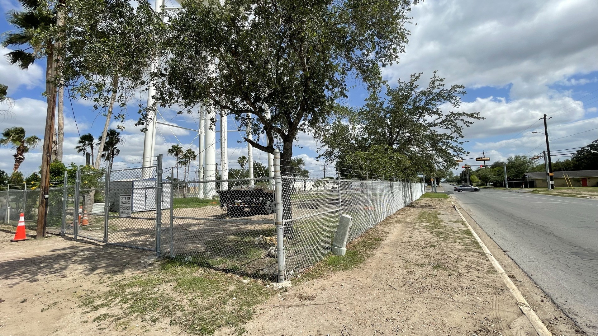 Chain link fence and gate following the roadside corner at the Weslaco water tower.
