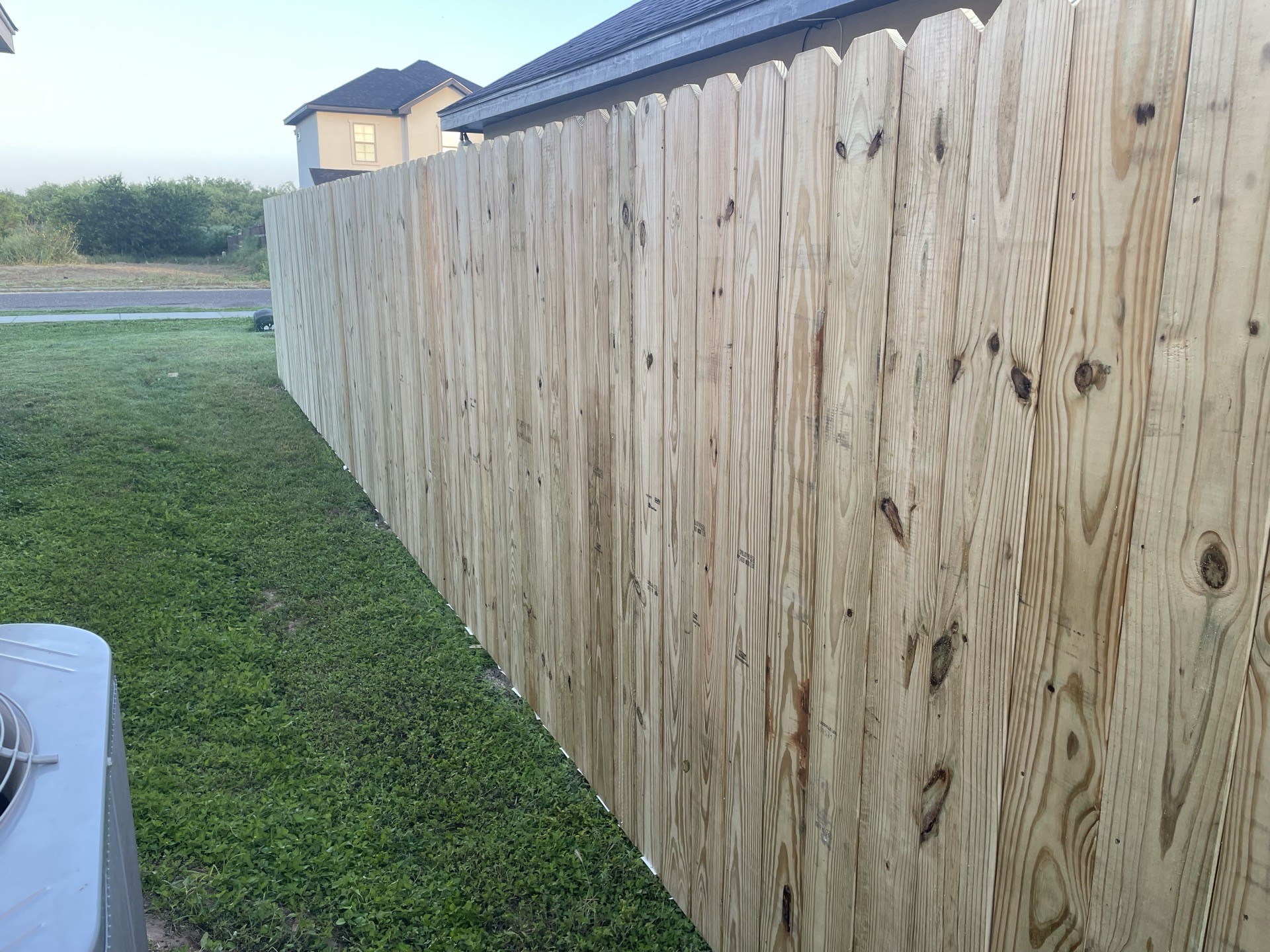 Wood privacy fence running along a grassy side yard in Weslaco.