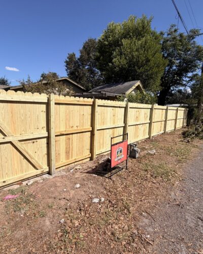Wood privacy fence and diagonally braced gate beside an alley
